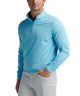 Light blue quarter-zip pullover with long sleeves, worn with light trousers