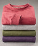 Folded melange interlock crew pullover stack in red, grey, pine, and deep purple.