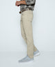 Light khaki stretch denim jeans in profile with belt loops and button closure.